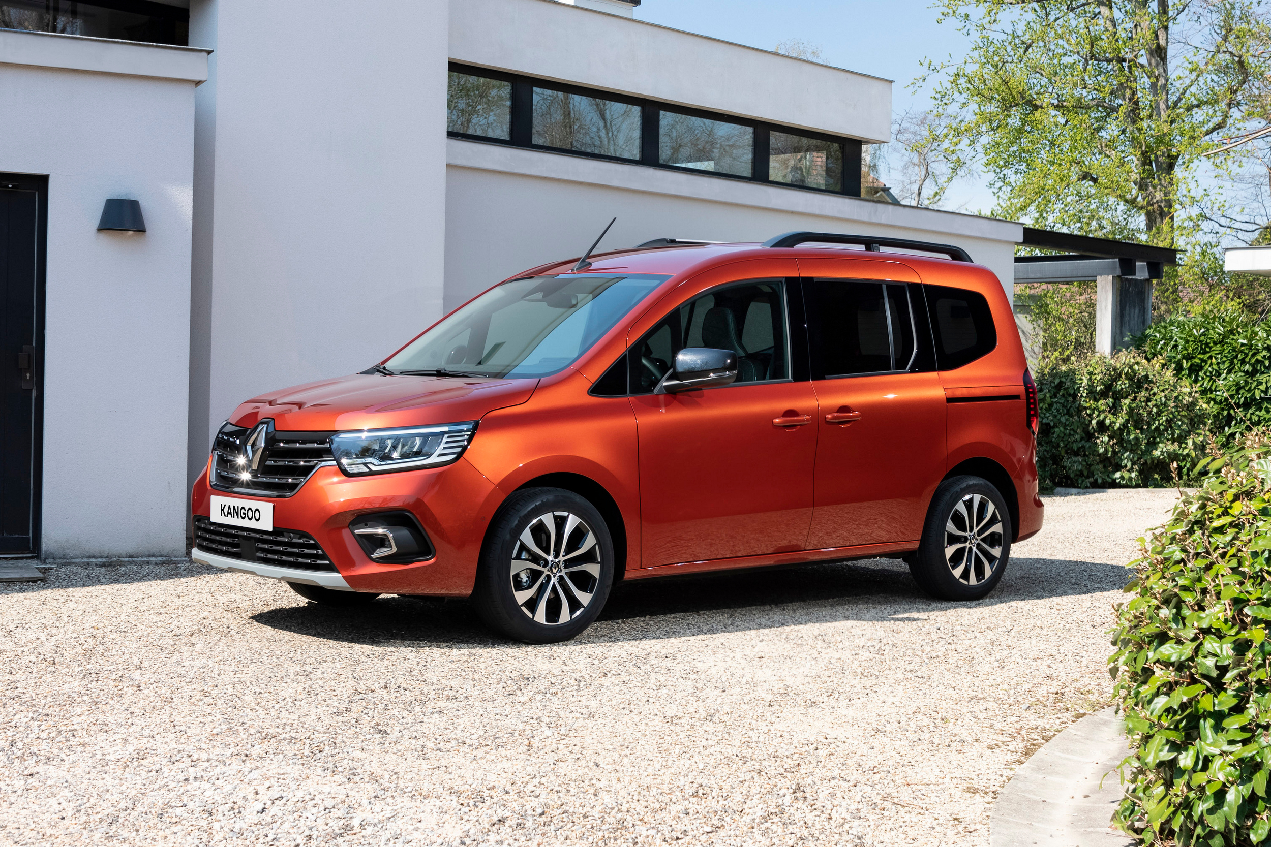 Terracotta Brown rudos spalvos Renault KANGOO vienatūris, pastatytas šalia balto pastato