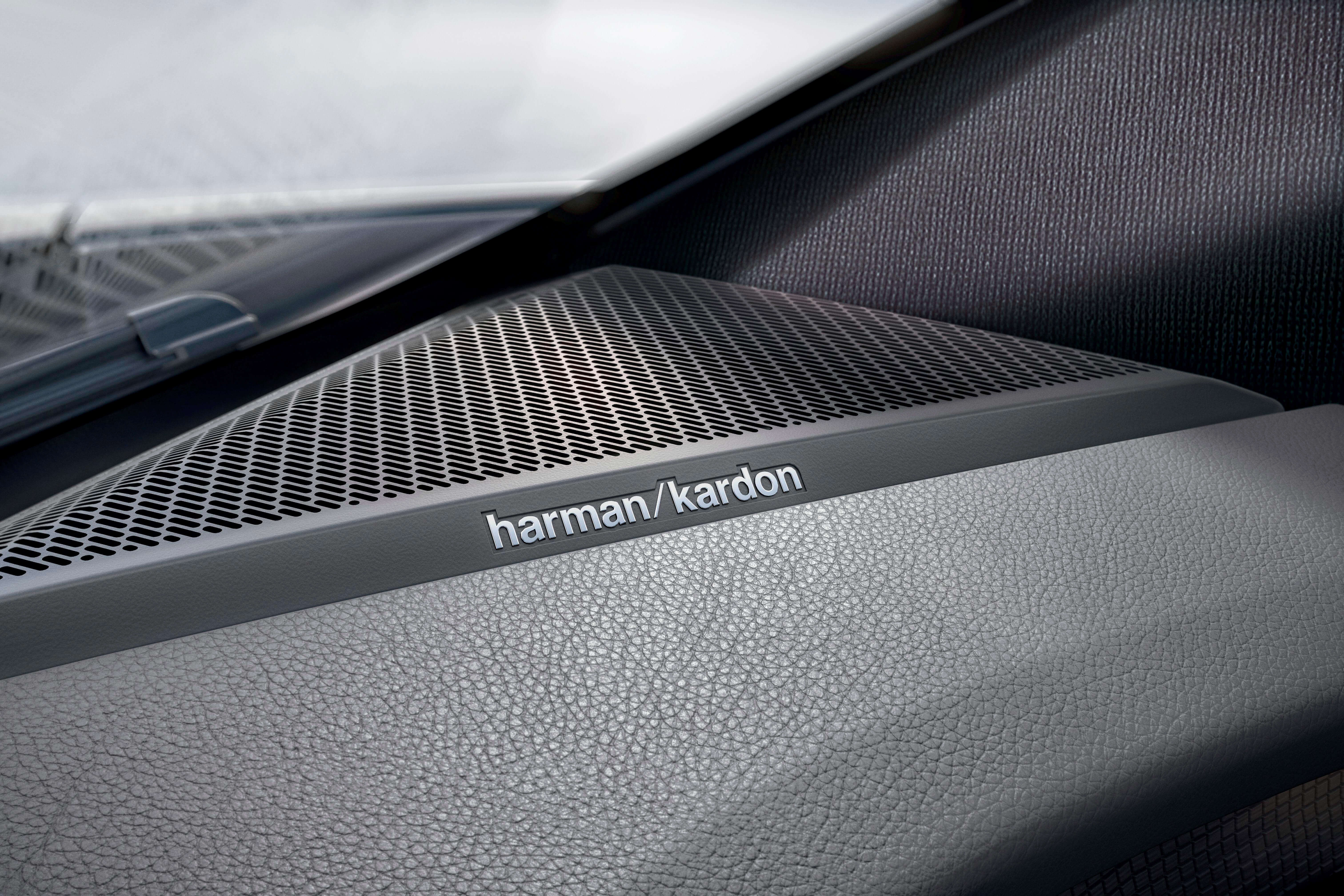 Visiškai elektrinio Renault MEGANE E-TECH Electric prietaisų skydo viršuje matomas Harman Kardon garso sistemos garsiakalbio vaizdas stambiu planu