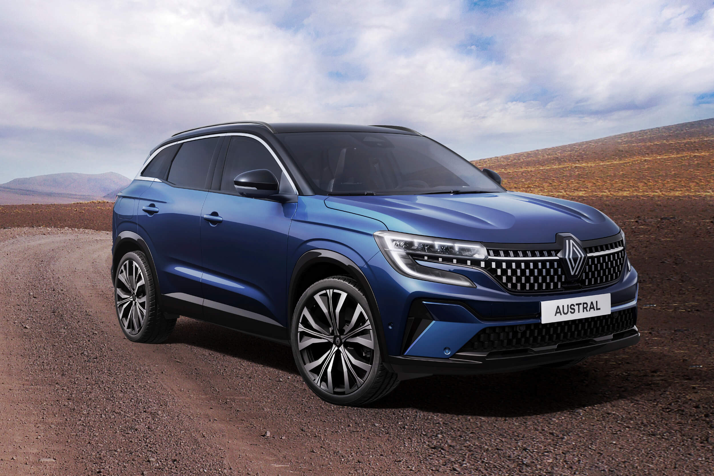 Mėlynas Renault Austral visureigis, stovintis kampu, matomas šonas ir priekinė dalis