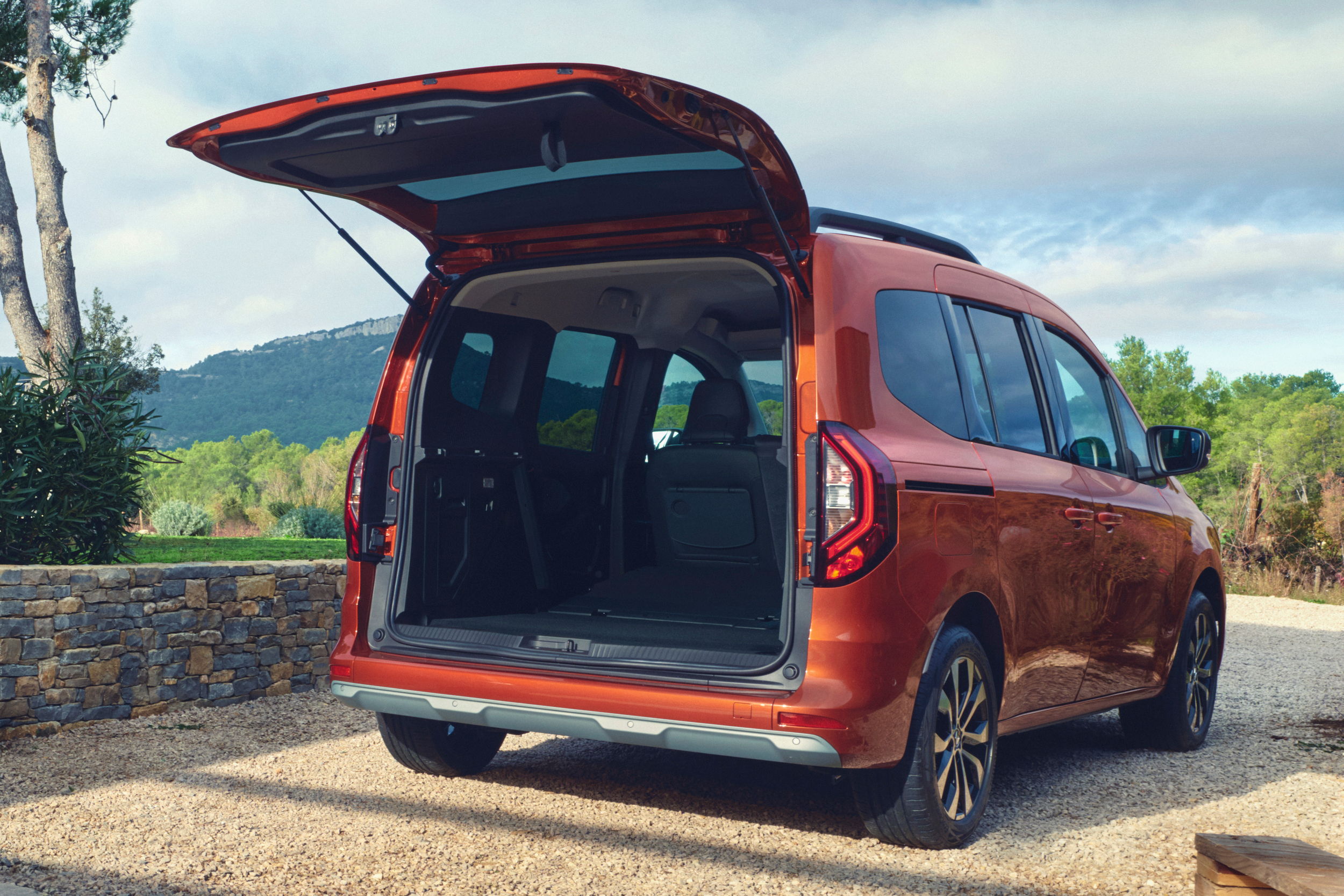 Terracotta Brown rudos spalvos Renault KANGOO vienatūris su atidarytu bagažinės dangčiu, matomas iš galinės pusės