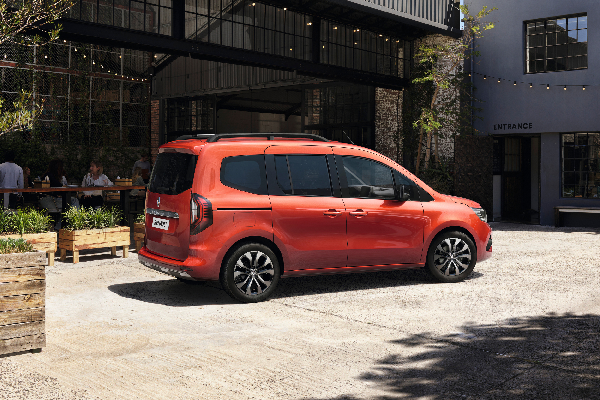 Terracotta Brown rudos spalvos Renault KANGOO vienatūris, pastatytas nedideliame kiemelyje prie kavinės