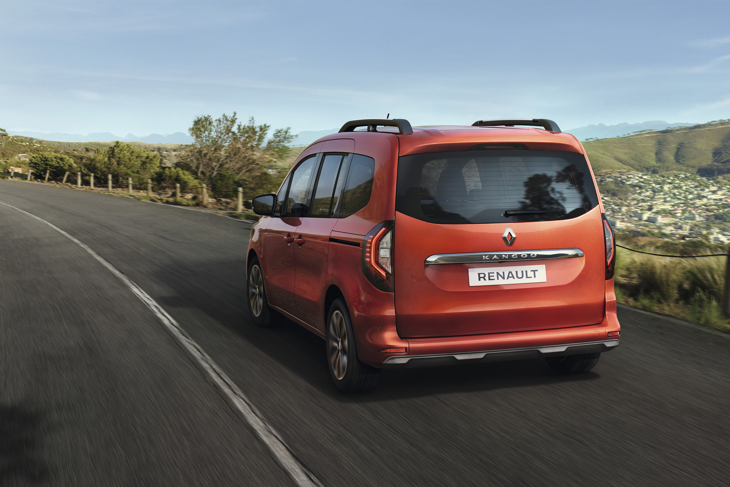 Terracotta Brown rudos spalvos Renault KANGOO vienatūris, matomas iš galinės pusės, važiuoja keliu